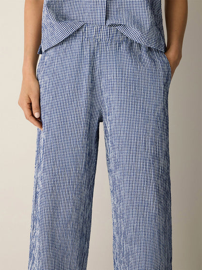 Person wearing Eileen Fisher Organic Cotton Pucker Check Wide-Leg Pant in Light Dive with hands in pockets; matching top is partially visible.