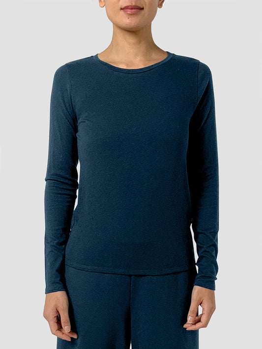 A person wearing the Eileen Fisher Sheer Cotton Blend Knit Round Neck Tee in Alpine with matching pants, standing against a plain light gray background.