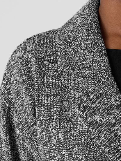 Close-up of the Eileen Fisher Organic Cotton Tweed Short Blazer in Black/White, showcasing its textured design, visible stitching, and peek of a black inner garment, all crafted with Fair Trade Certified practices.