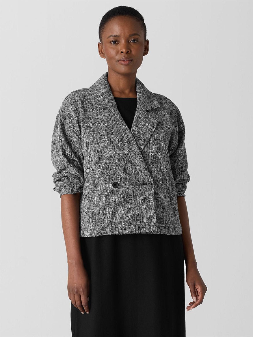 Person wearing an Eileen Fisher Organic Cotton Tweed Short Blazer in Black/White over a black shirt, standing against a plain background.