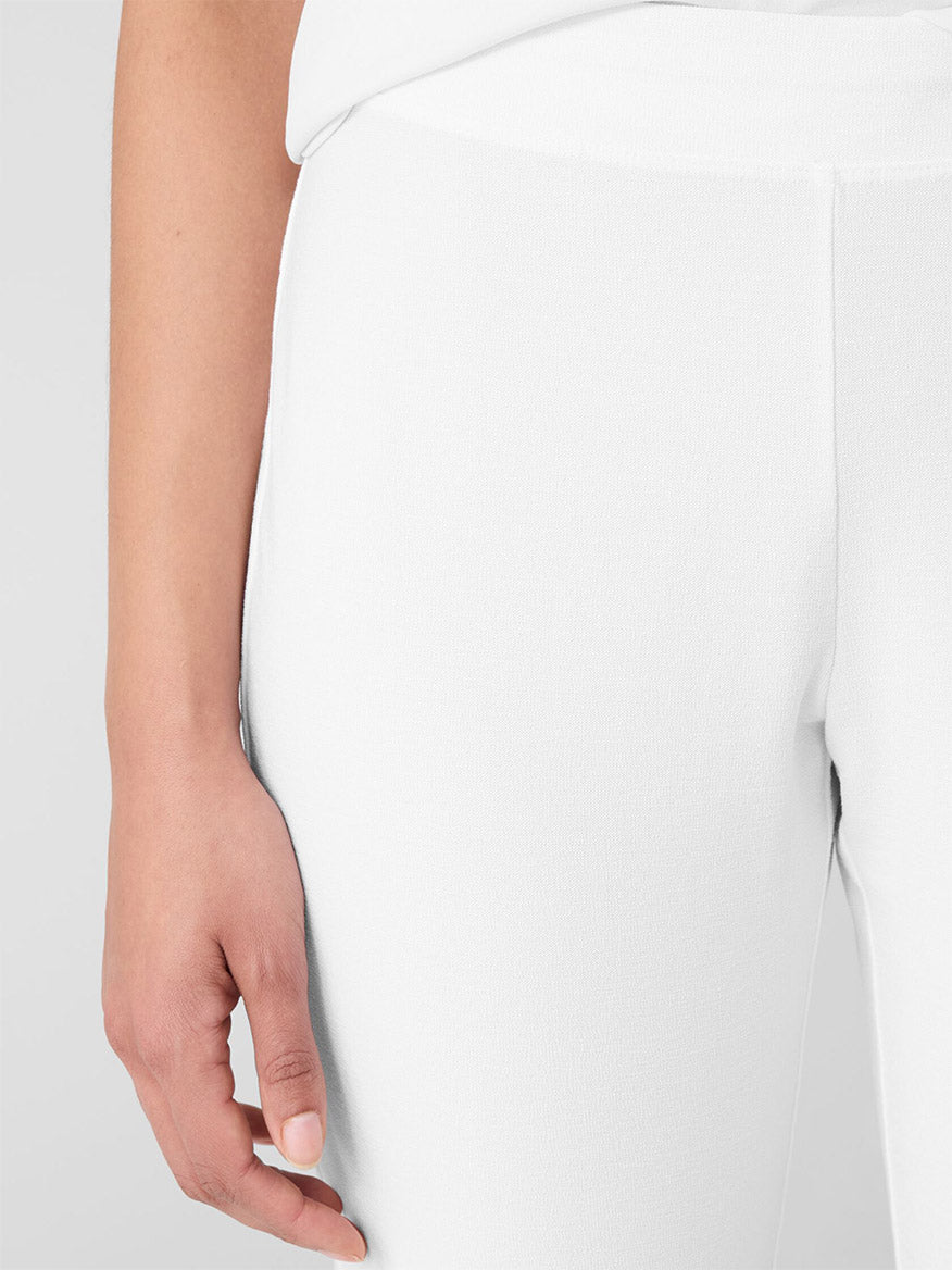 Close-up of a person wearing the Eileen Fisher Washable Stretch Crepe Pant in white, paired with a matching top. The focus is on the left hip and hand, exuding elegance.