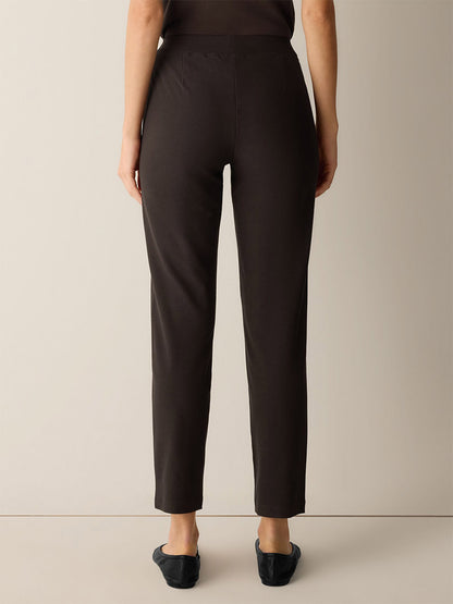 Back view of Eileen Fisher Washable Stretch Crepe Slim Pant in Coffee, a dark brown slim pant paired with black flats.