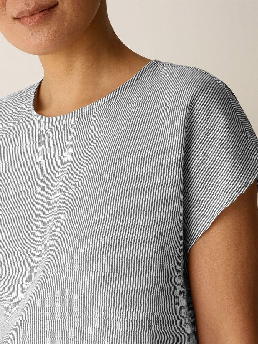 A person wears the Eileen Fisher Striped Linen Sheen Square Top in Wheat; only their lower face, neck, shoulders, and upper chest are visible.