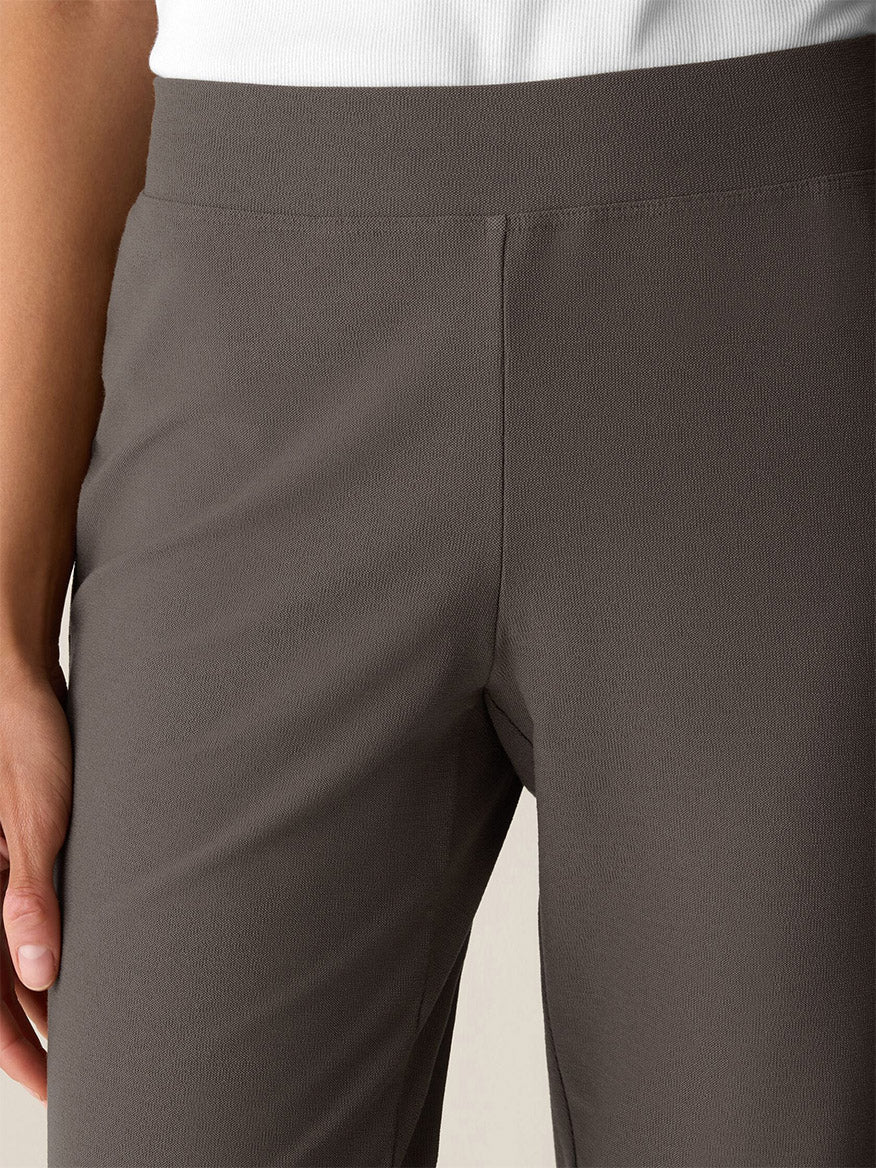 A person wearing the Eileen Fisher Washable Stretch Crepe Slim Pant in Cobblestone and a white shirt, with one hand resting by their side.