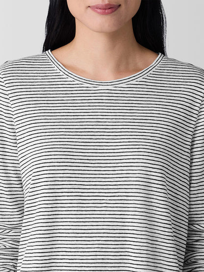 A person wears the Eileen Fisher Striped Organic Linen Jersey Long-Sleeve Tee in White/Black, featuring a crew neck and visible black and white stripes from the shoulders up against a plain background.