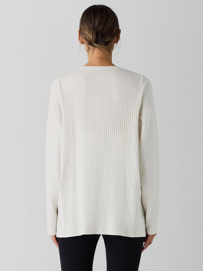 Back view of someone wearing the Eileen Fisher Textured Stretch Rib Round Neck Long-Sleeve Top in Bone with black pants, set against a plain background.