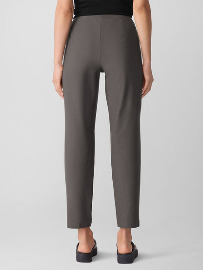 A person is seen from the back wearing Eileen Fisher Washable Stretch Crepe Pant in Rye with black shoes, against a plain light background.