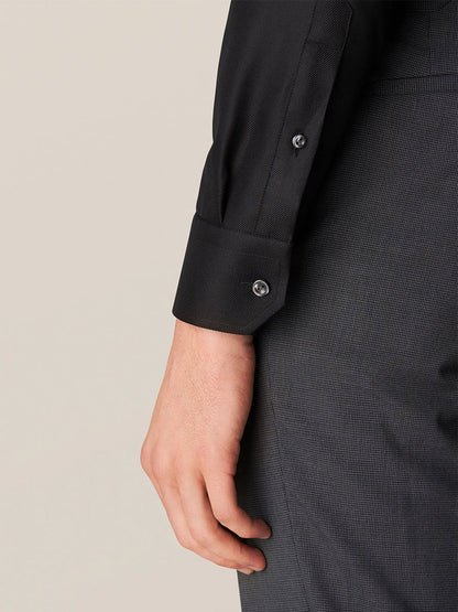 The hand of a man wearing an Eton Contemporary Fit Black Textured Twill Dress Shirt.