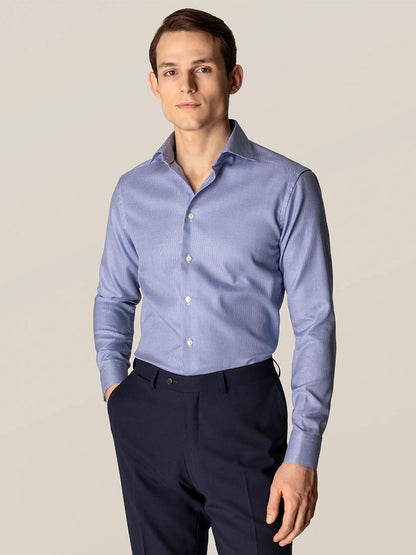 A man in an Eton Contemporary Fit Mid Blue Patterned Twill Dress Shirt with navy pants.