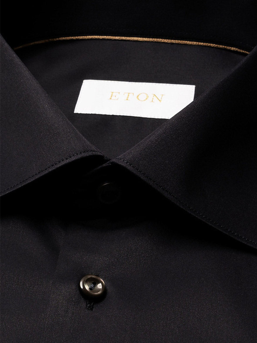 Close-up of a black Eton Contemporary Fit Solid Elevated Twill Dress Shirt featuring a pointed collar, visible buttons, and a branded interior neck label.