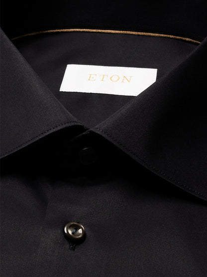 Close-up of a black Eton Contemporary Fit Solid Elevated Twill Dress Shirt featuring a pointed collar, visible buttons, and a branded interior neck label.