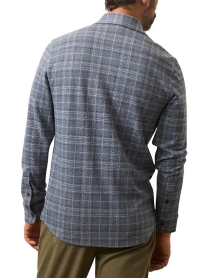 Man wearing a Faherty Brand Legend Sweater Shirt in Castle Lake Plaid, paired with khaki pants, shown from the back against a plain white background.