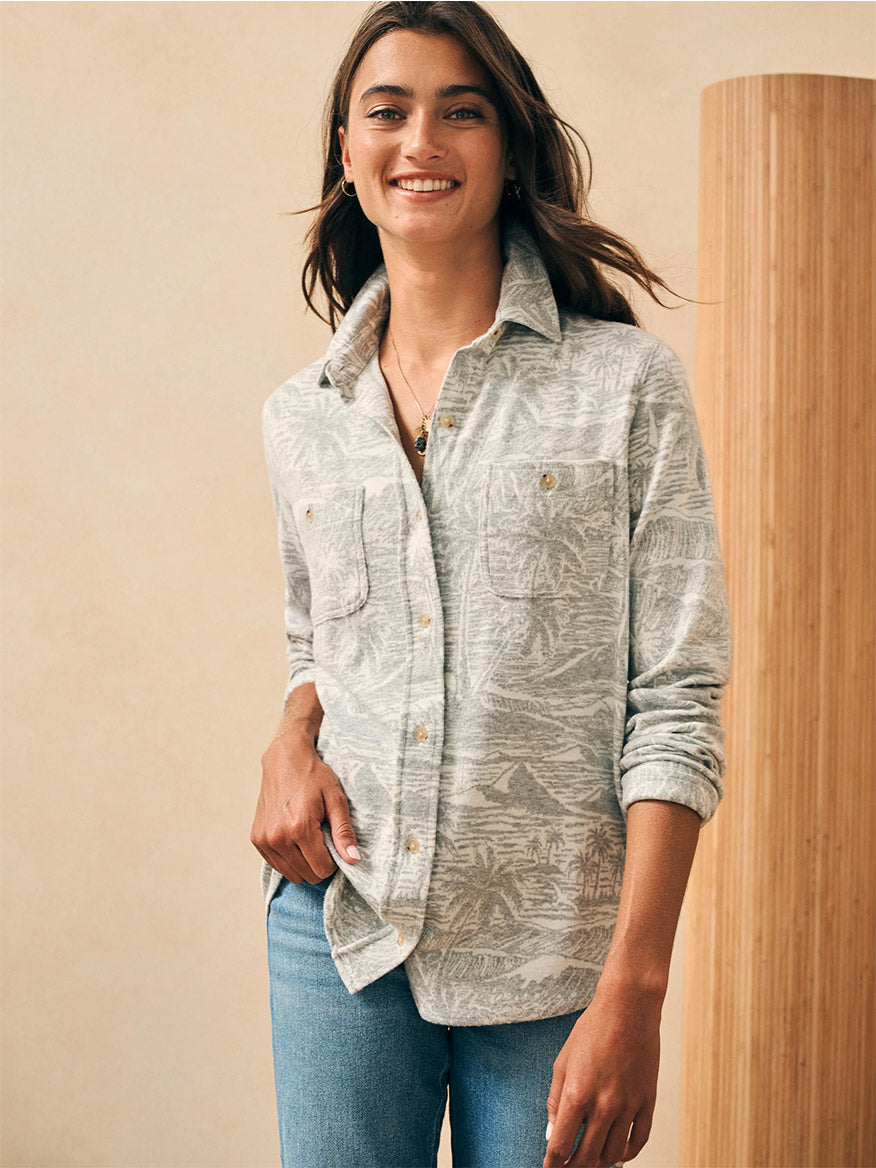 A woman in Faherty Brand Legend Sweater Shirt in Grey Coastal Waters is smiling.
