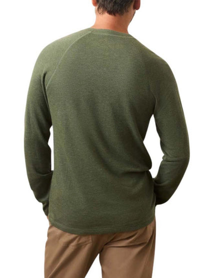 A man shown from the back against a white background wears the Faherty Brand Cloud Cotton Long-Sleeve Henley in Deep Fern Heather with khaki pants.