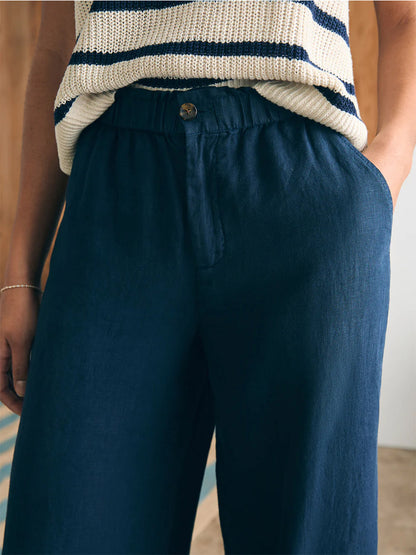 Close-up of a person wearing Faherty Brand Monterey Linen Pant in After Midnight and a cream striped knit top.