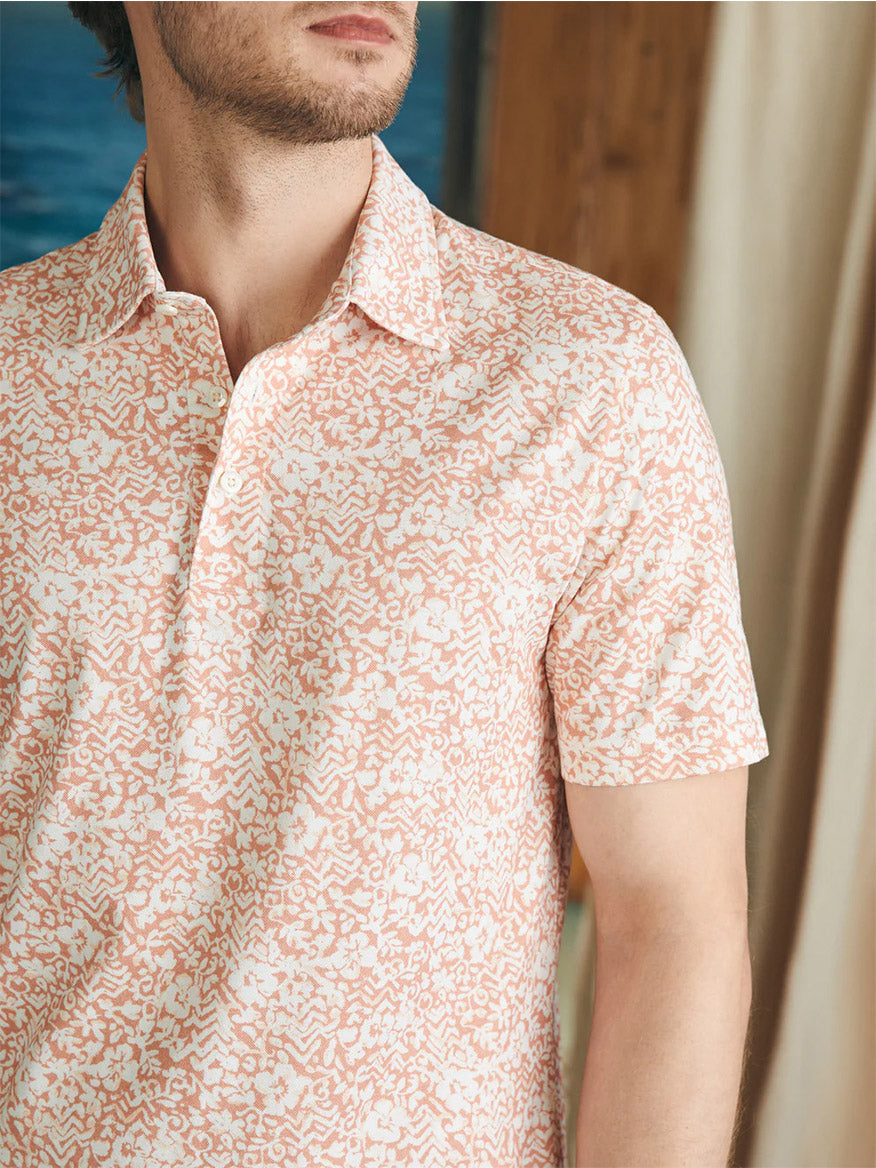 Man wearing a Faherty Brand Movement Short-Sleeve Polo in Hilo Rose Floral Print with a collar and vented hems.