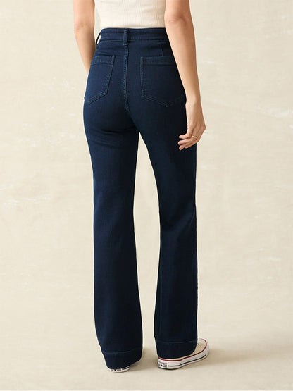 A person wearing the dark blue Faherty Brand Stretch Terry Patch Pocket Pant in Clermont and a white top stands with their back to the camera against a light background.