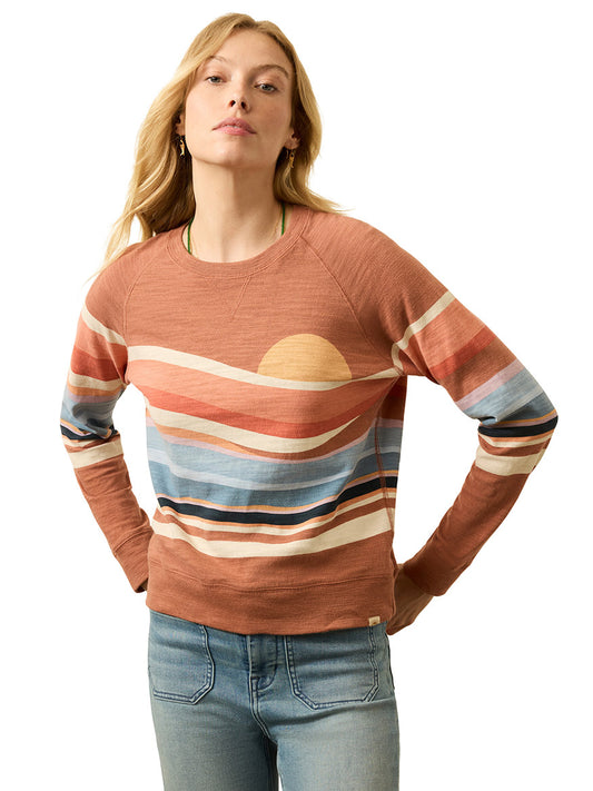 Wearing the Faherty Brand Sunwashed Slub Crewneck in Autumn Spritz Soleil with light blue jeans, a person stands against a plain white background.
