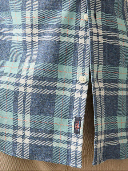 Close-up of the Faherty Brand Coastline Knit Shirt in Holbrook Island Plaid, featuring a blue and green plaid design with white buttons for comfort and wearability. A small black tag is sewn near the bottom hem.