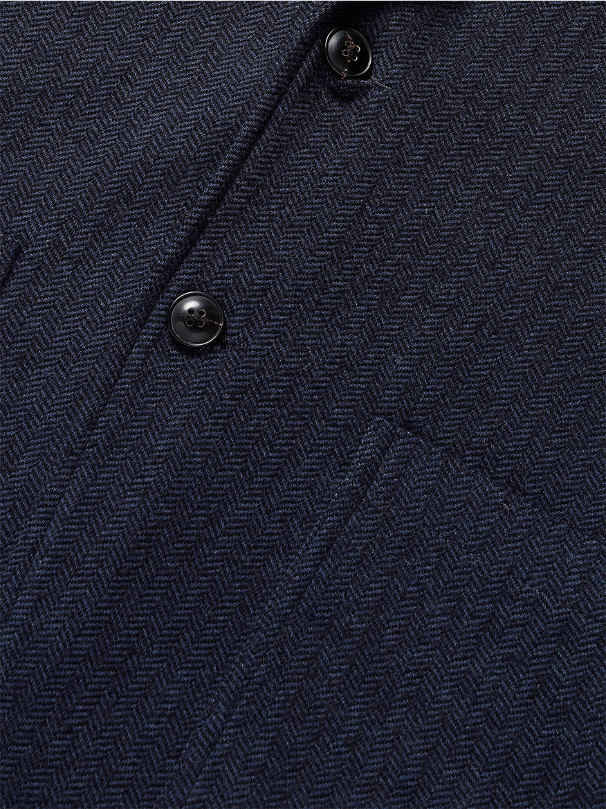 Close-up of the Faherty Brand Inlet Herringbone Blazer in Navy Twilight, highlighting its visible buttons and pocket. This versatile piece merges classic style with modern comfort, making it suitable for any occasion.