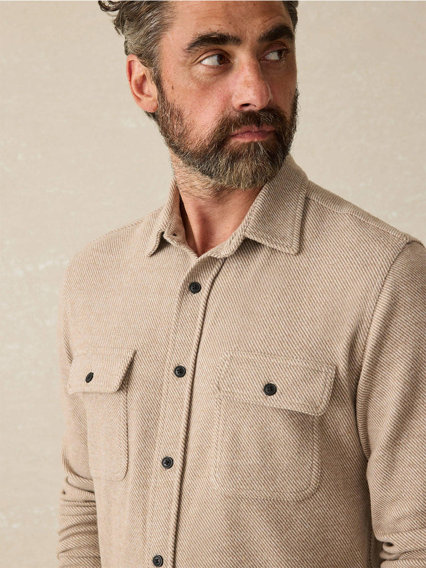 A man with a beard wearing the Faherty Brand Legend Sweater Shirt in Timber Twill looks to the side against a neutral background.