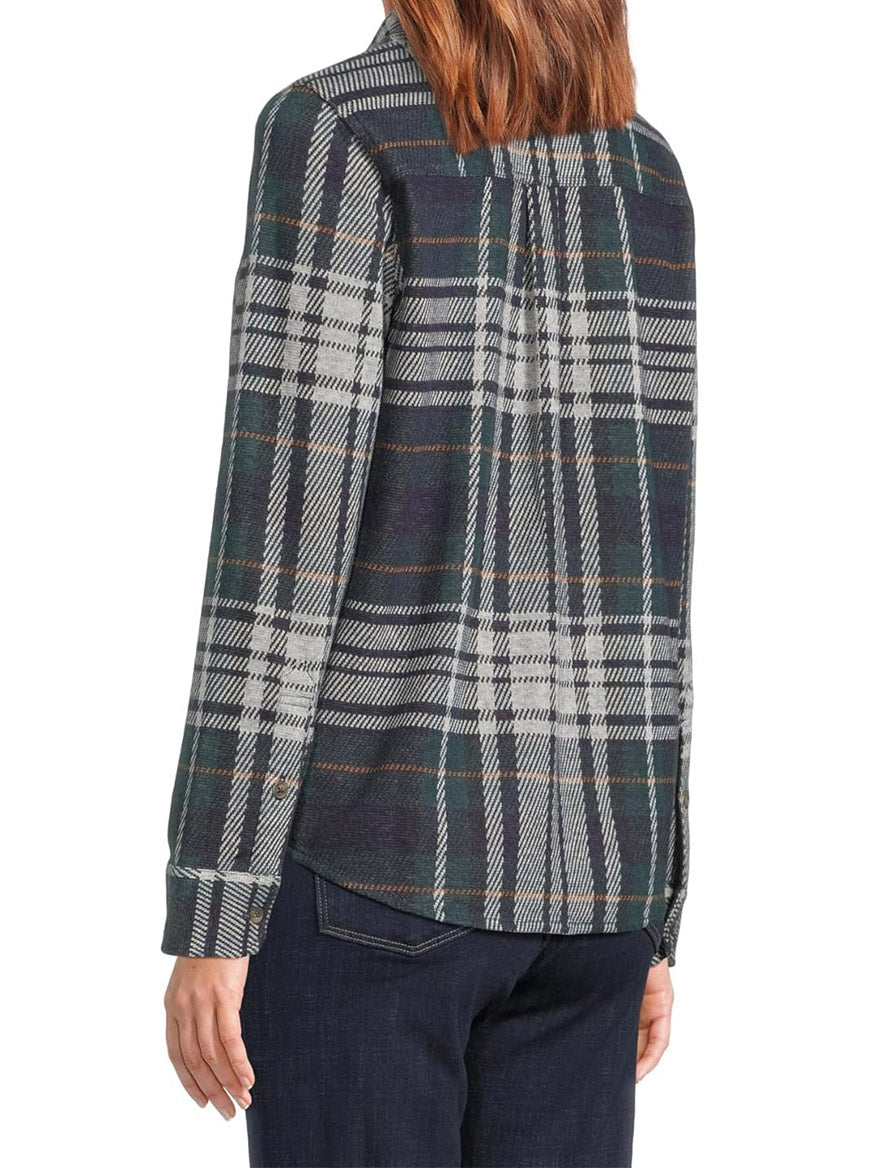 The individual is seen from behind, wearing a Faherty Brand Legend Sweater Shirt in Blue Ridge Plaid—a striking green and white plaid crafted from a custom fabric blend with long sleeves.