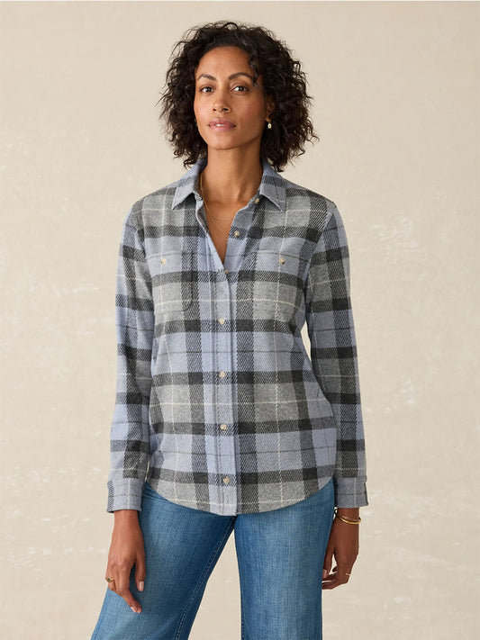 The individual is wearing the Faherty Brand Legend Sweater Shirt in True North Plaid, paired with classic blue jeans against a plain background.