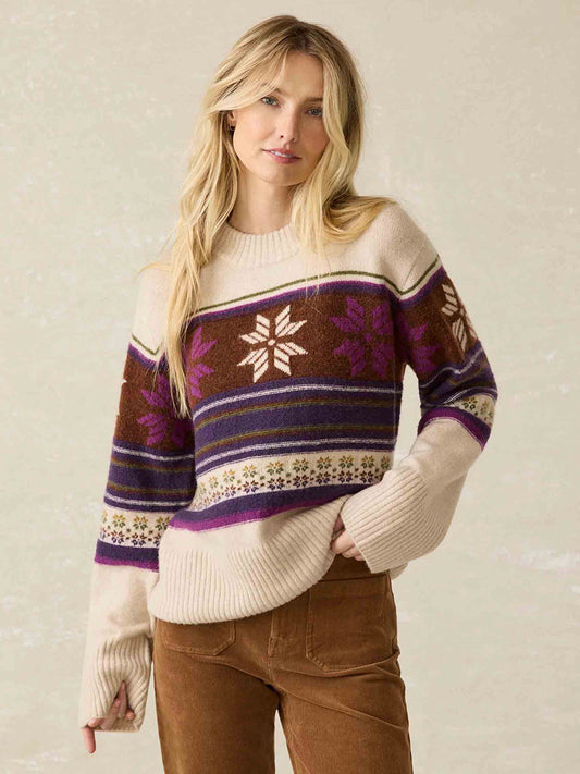 A person in the Faherty Brand Snowdrift Sweater in Multi Snowflake stands against a light background.