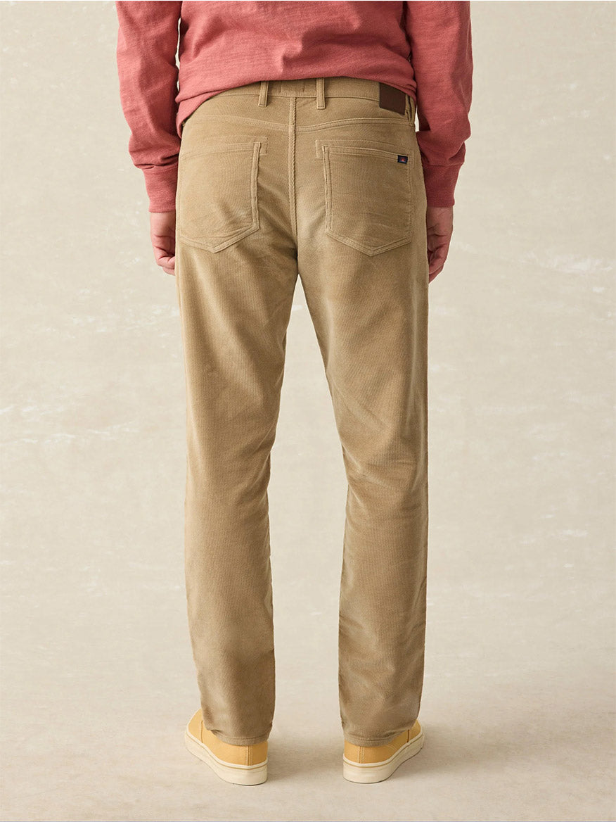 A person wearing Faherty Brand Stretch Terry 5-Pocket Pant in Barley and a red shirt is viewed from the back.