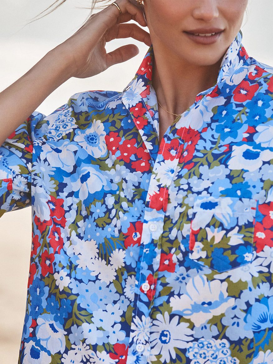 Close-up of a woman in the Frank & Eileen Eileen Relaxed Button-Up Shirt in Blue & Red Floral, showcasing its bust-flattering buttons and laid-back California style. Only her lower face and part of her arm are visible.