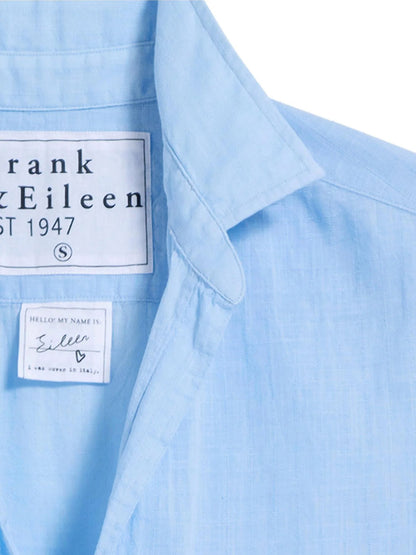 Close-up of the Frank & Eileen Eileen Relaxed Button-Up Shirt in Textured Blue, highlighting two labels: one displaying the "Frank & Eileen" brand and another with handwritten-style text reading "Hello my name is Eileen.