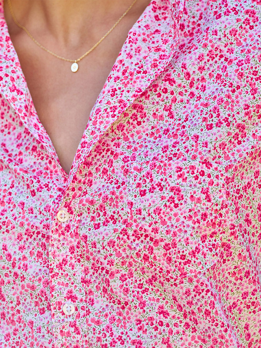 Close-up of a person wearing the Frank & Eileen Eileen Relaxed Button-Up Shirt in Pink Flowers, styled with a delicate gold necklace featuring a small round pendant.