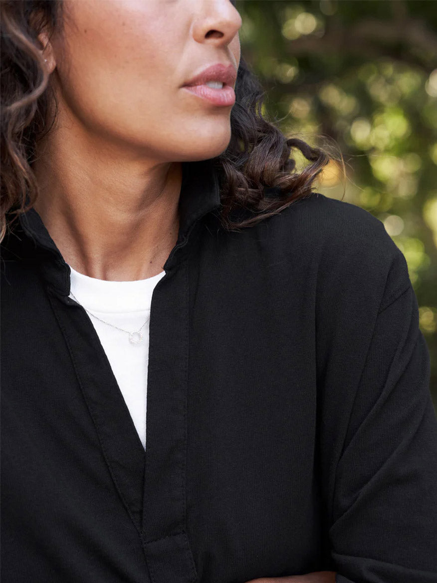Close-up of a woman in a Frank & Eileen Patrick Popover Henley in Black, focusing on her lower face and neckline, showing subtle jewelry and natural makeup.