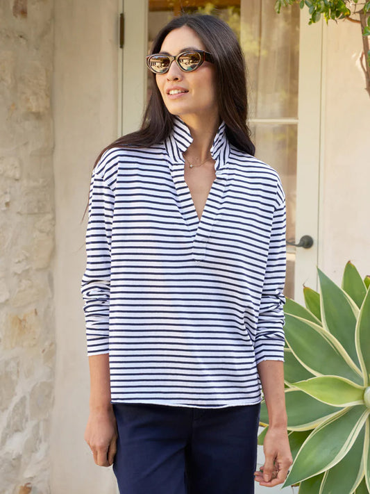 Woman wearing a striped Frank & Eileen Patrick Popover Henley in White/British Royal Navy Stripe Heritage Jersey and sunglasses, standing outdoors near a plant.