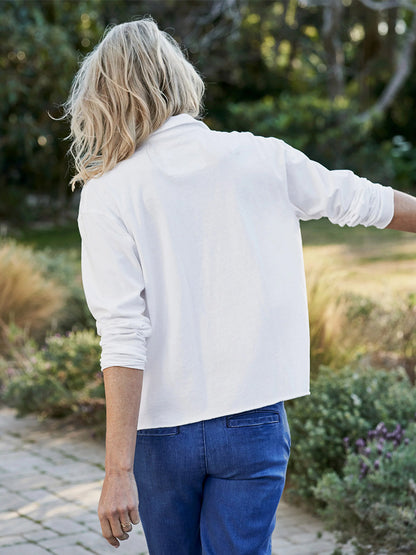 Woman walking in a garden wearing a Frank & Eileen Patrick Popover Henley in Vintage White Heritage Jersey and blue jeans.