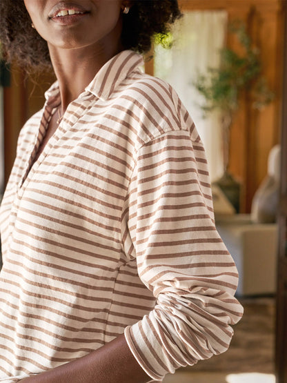 A person wears the Frank & Eileen Patrick Popover Henley in Vintage White & Camel Stripe Heritage Jersey indoors with natural light in the background.