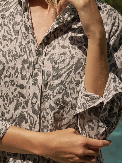 Wearing the Frank & Eileen Rory Maxi Shirtdress in Glitter Animal Print, styled with California chic flair, a person stands outdoors by the pool with arms crossed and one hand touching the collar.