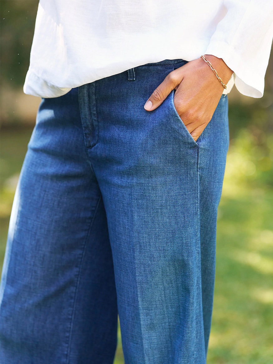 Someone wearing the Frank & Eileen West Village NYC Wide-Leg Trouser in 1984 Wash and a white shirt stands outdoors with one hand in their pocket.