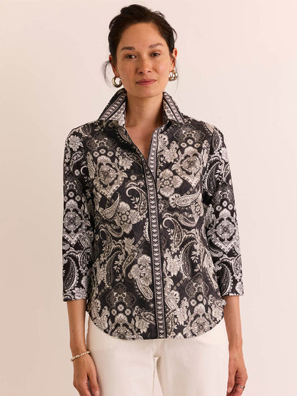A woman poses against a plain background, wearing the Hinson Wu Lizette 3/4 Sleeve Top in Black Paisley and white pants.