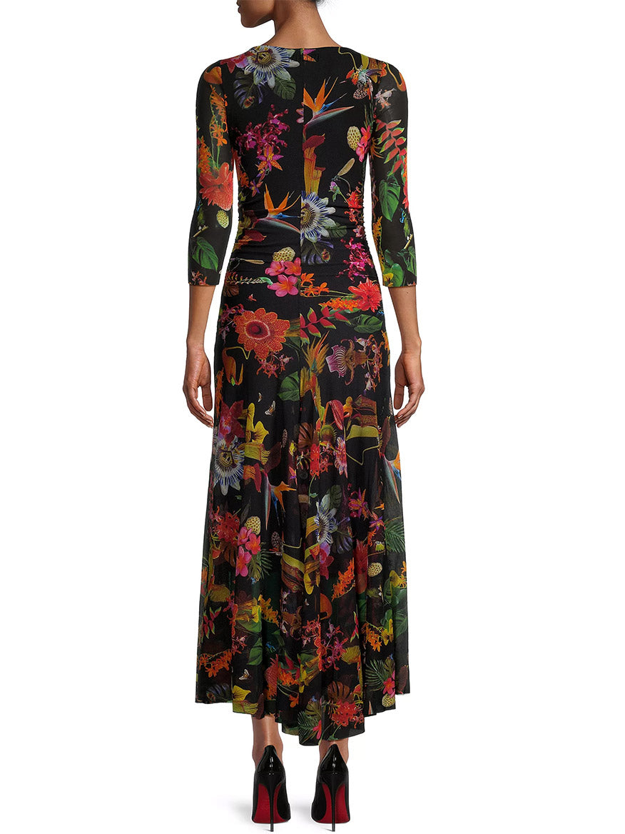 A person stands showcasing a Fuzzi Abito Floral Maxi Dress in Nero Multi, paired with red high heels.