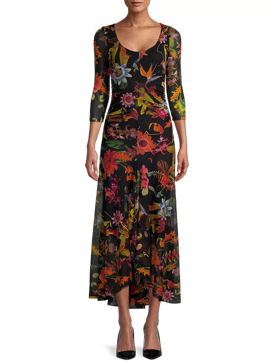 A woman in a Fuzzi Abito Floral Maxi Dress in Nero Multi and black heels stands against a plain background.