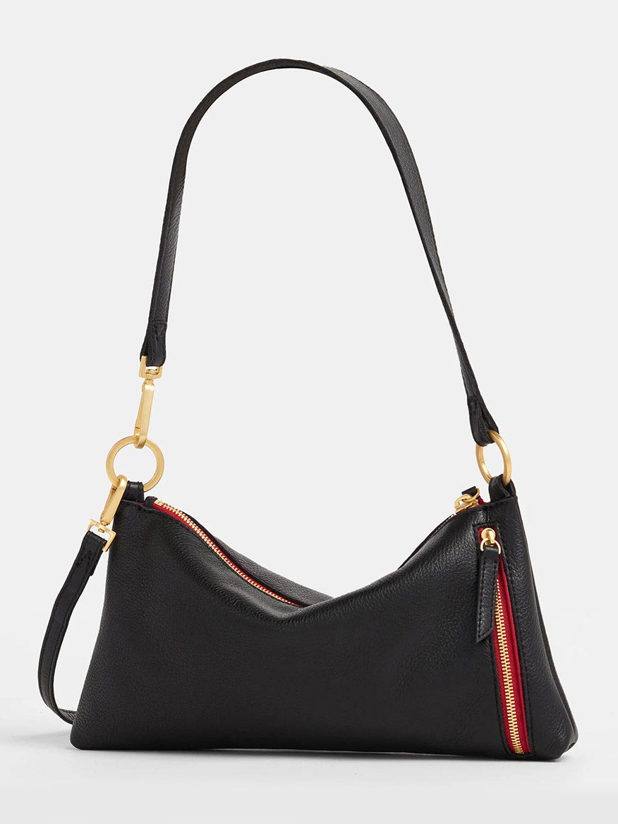 The Hammitt Los Angeles Kyle Shoulder Bag in Black with Brushed Gold accents and a Red Zip is crafted from black pebbled leather, offering a curved silhouette. It includes an adjustable crossbody strap for added convenience.