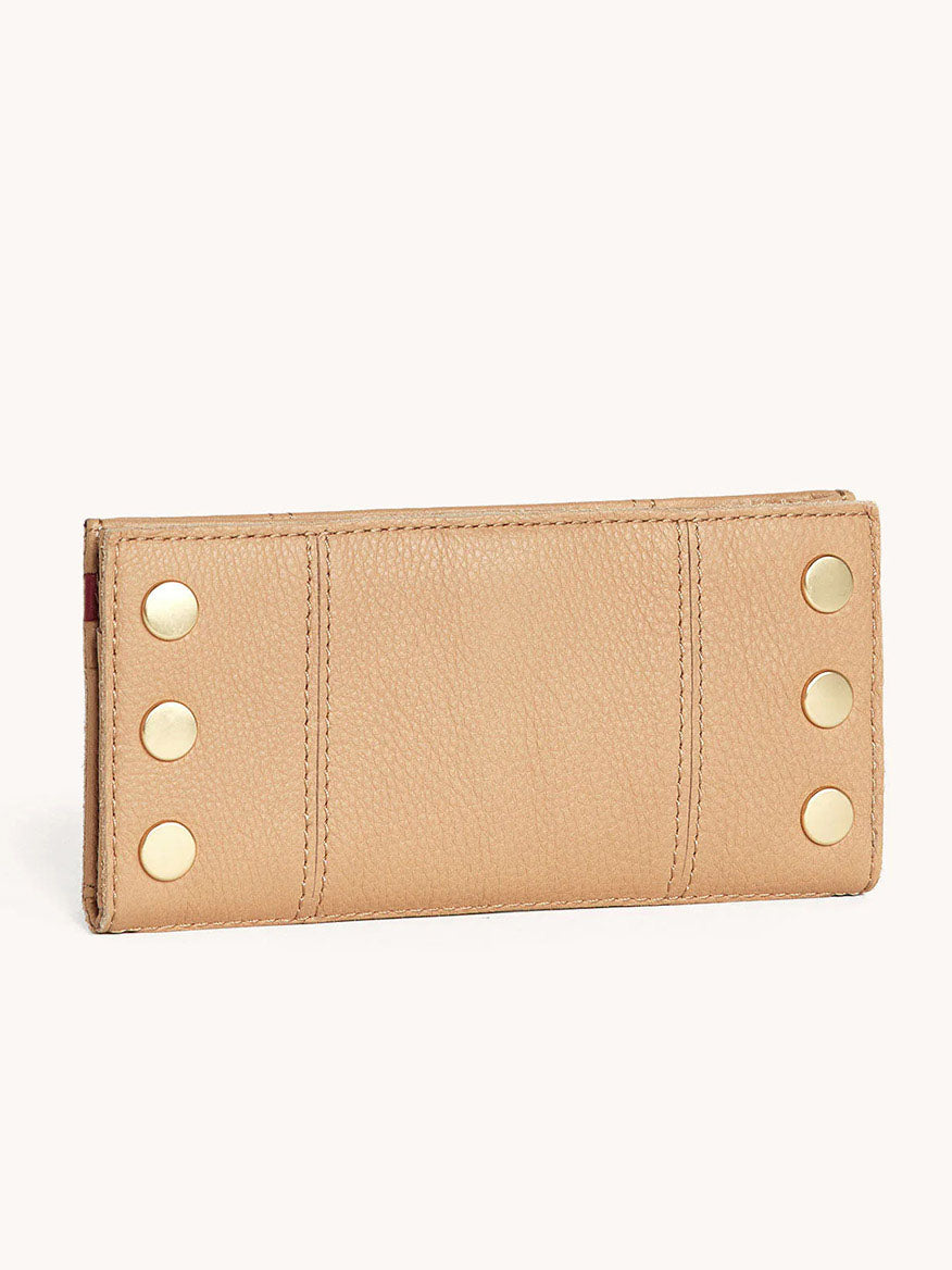 The Hammitt Los Angeles 110 North Wallet in Toast Tan is a beige folding wallet made from pebbled leather with six gold rivets in two vertical rows on the front and offers multiple slots for credit cards.