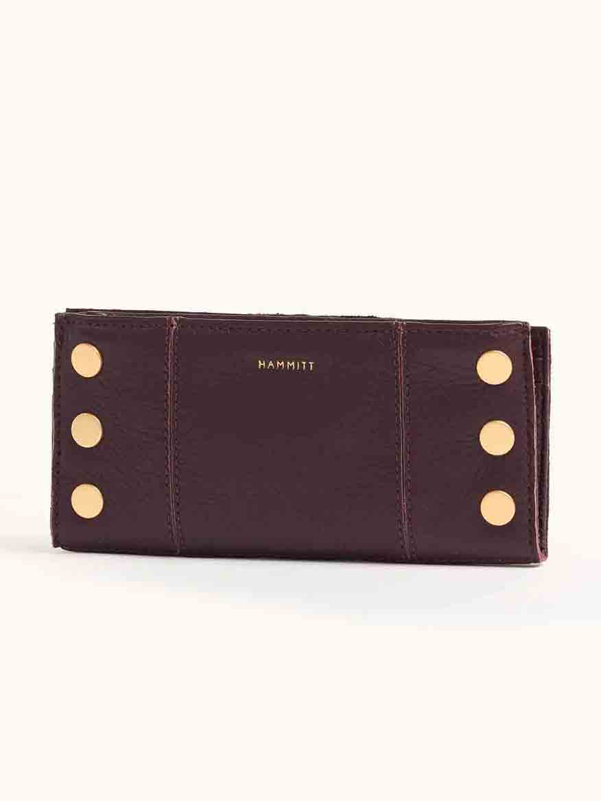 Crafted in luxurious cabernet pebble, the Hammitt Los Angeles 110 North Wallet features stylish gold rivet accents and proudly displays the Hammitt brand name on the front. Its impeccable design includes convenient credit card slots, merging functionality with elegance.