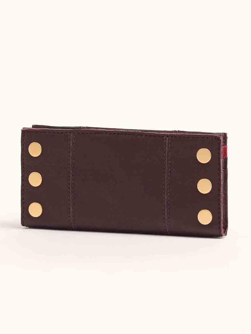 The Hammitt Los Angeles 110 North Wallet in Cabernet Pebble, crafted from brown leather with a rich burgundy hue and adorned with gold button accents, is shown closed.