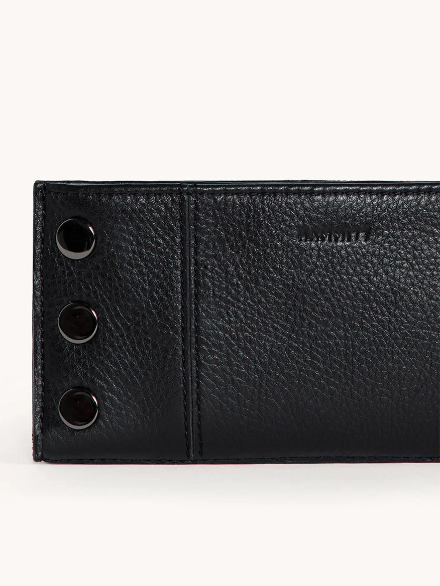 The Hammitt Los Angeles 110 North Wallet in Black/Gunmetal features black pebble leather and three metal snap buttons on the left side, shown against a plain light background.