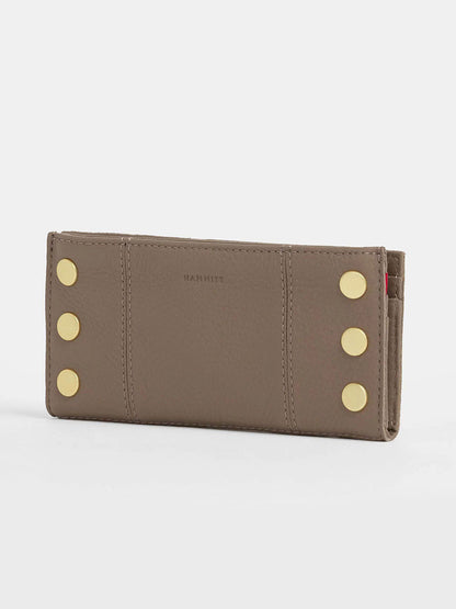 The Hammitt Los Angeles 110 North Wallet in Sculpted Taupe is a taupe folding wallet made from pebbled leather, featuring gold button accents on both ends and "HAMMITT" embossed in the center, with convenient credit card slots inside.