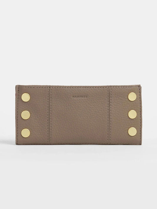 The Hammitt Los Angeles 110 North Wallet in Sculpted Taupe is a taupe pebbled leather wallet with six gold studs in two vertical rows on the front and convenient credit card slots.