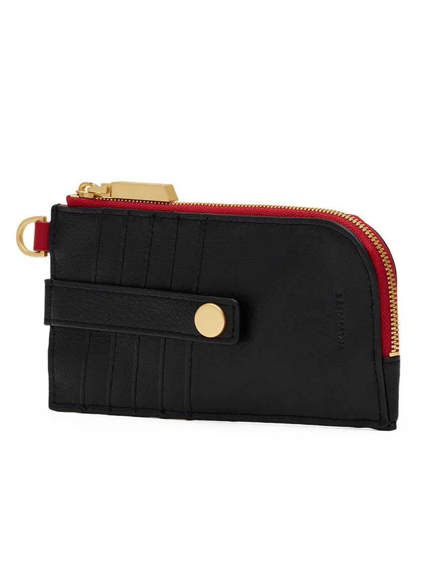 The Hammitt Los Angeles 210 East Wallet in Black/Brushed Gold/Red Zip features pebbled black leather, a brushed gold zipper, red trim accents, and a snap-button strap detail. Shown against a white background, this slim wallet with D-ring takes inspiration from the iconic Hammitt 210 East design.