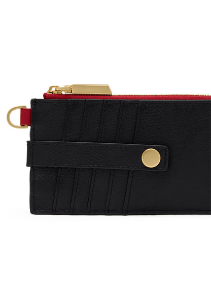 Introducing the Hammitt Los Angeles 210 East Wallet in Black/Brushed Gold/Red Zip—a slim, black pebbled leather wallet accented with brushed gold hardware and a vibrant red zipper. Featuring a convenient D-ring, gold button detailing, and stitched card slots on one side for organized storage, this wallet blends sleek style with practical functionality, inspired by the iconic Hammitt 210 East collection.